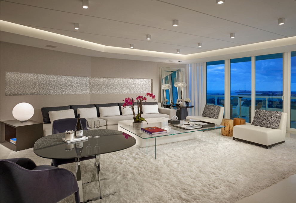 This is an example of a large contemporary open concept living room in Miami with grey walls and limestone floors.