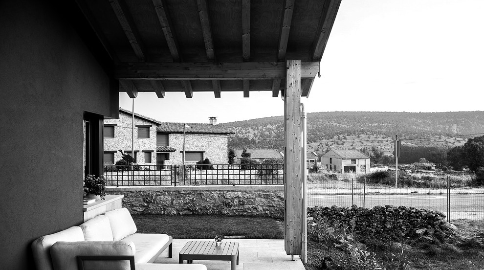 Ejemplo de terraza de estilo de casa de campo grande en patio delantero con suelo de baldosas y pérgola