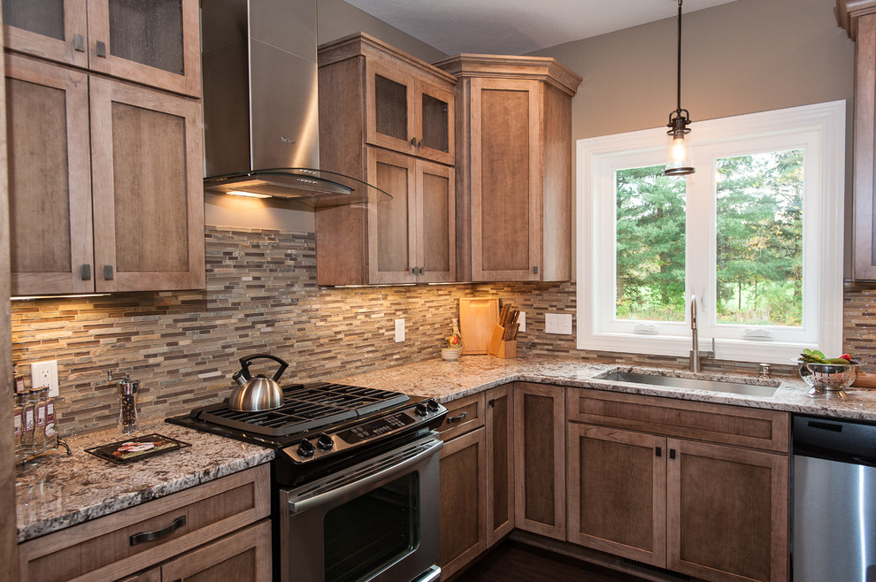 Inspiration for a traditional eat-in kitchen in Cleveland with flat-panel cabinets, medium wood cabinets, granite benchtops, beige splashback and stainless steel appliances.