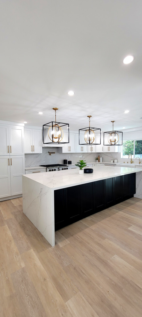 Professionally installed white and black Kitchen Cabinet Mississauga design featuring a waterfall island, gold hardware, and geometric pendant lights