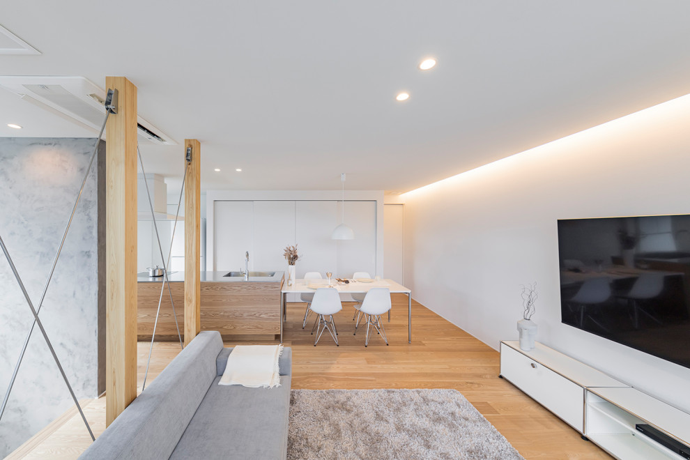 Offenes Modernes Wohnzimmer mit weißer Wandfarbe, braunem Holzboden, TV-Wand und Tapetendecke in Sonstige
