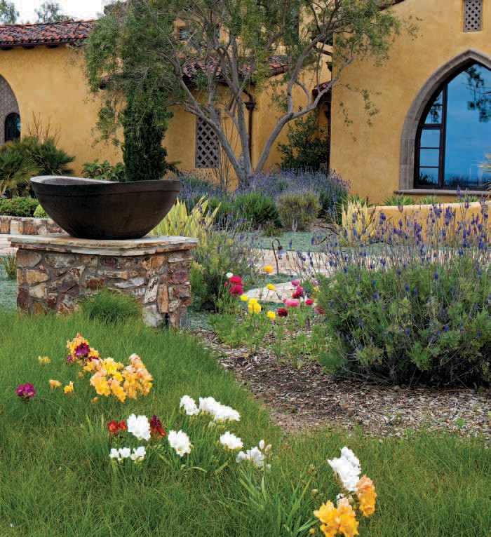 This is an example of a large mediterranean two-story stucco landscaping in San Diego with a tile roof.