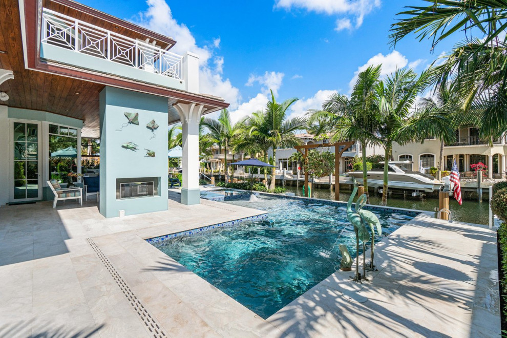 Large beach style backyard l-shaped pool in Miami with a hot tub and tile.