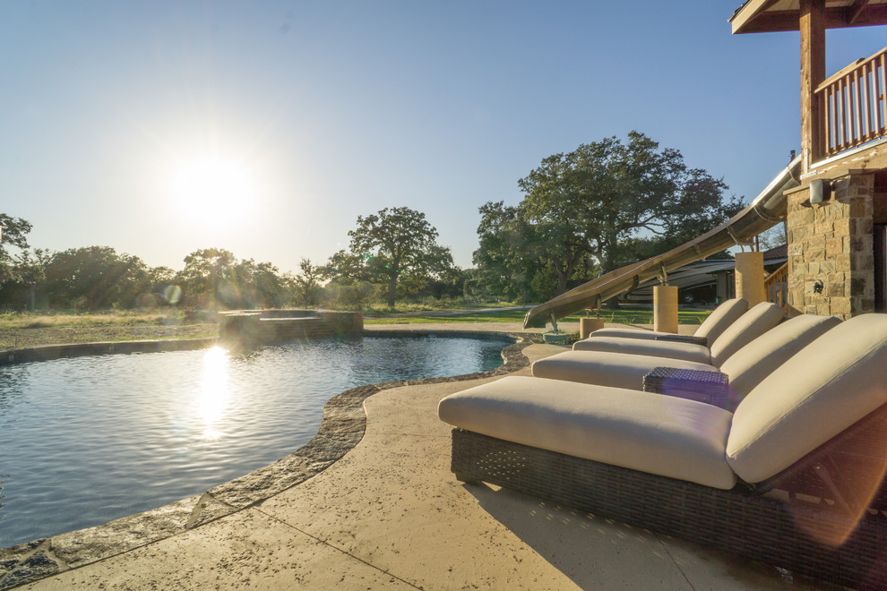 Water slide - large rustic backyard stone and custom-shaped water slide idea in Austin