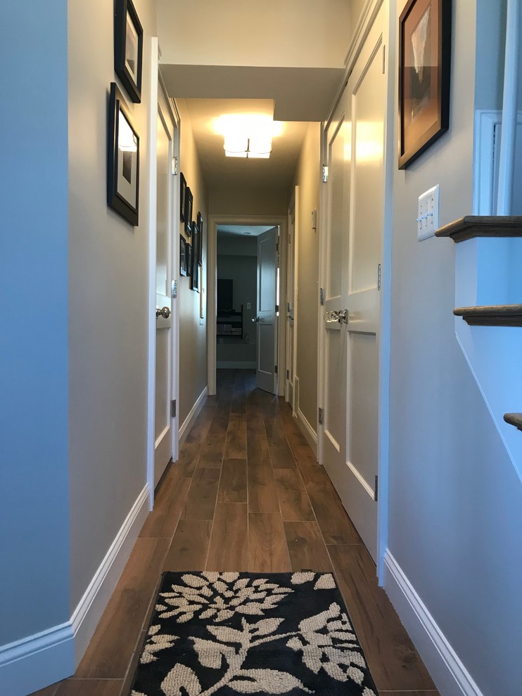 Photo of a mid-sized transitional walk-out basement in Boston with grey walls, ceramic floors and brown floor.