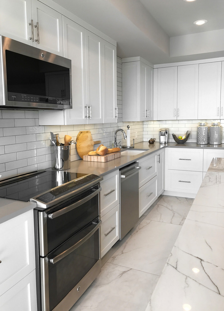 Open concept kitchen - large transitional l-shaped open concept kitchen idea with an undermount sink, subway tile backsplash, stainless steel appliances and an island
