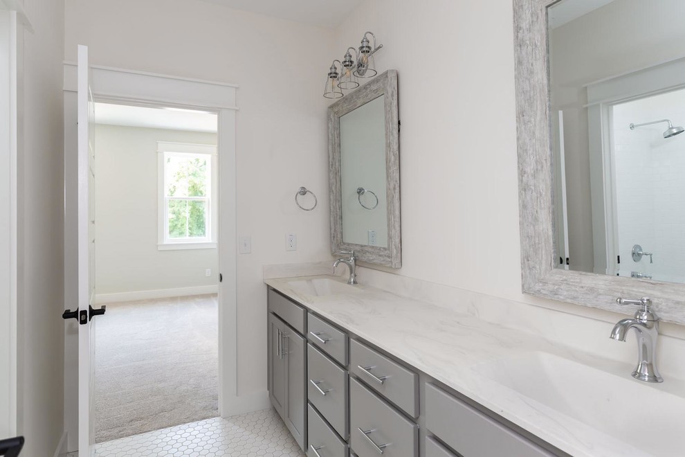 This is an example of a mid-sized country kids bathroom in Raleigh with shaker cabinets, grey cabinets, an alcove tub, a shower/bathtub combo, a two-piece toilet, white tile, ceramic tile, white walls, ceramic floors, an integrated sink, marble benchtops, white floor and white benchtops.