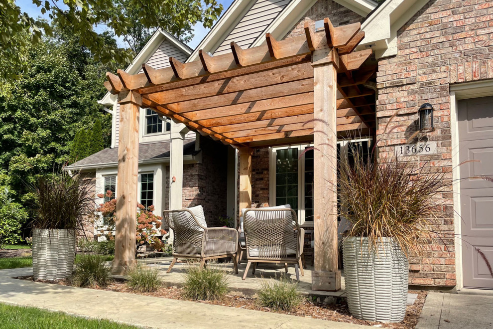Inspiration for a beach style front yard patio in Indianapolis with concrete slab and a pergola.