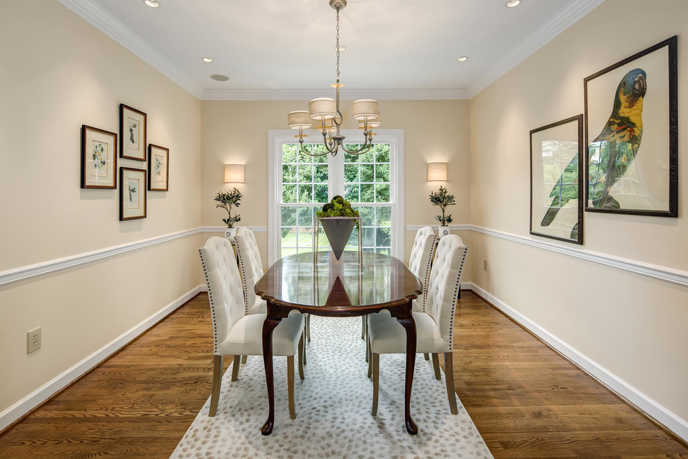 This is an example of a traditional dining room in DC Metro with beige walls, dark hardwood floors and brown floor.
