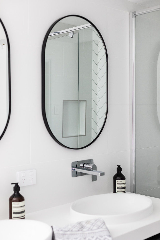 Inspiration for a mid-sized contemporary kids bathroom in Brisbane with shaker cabinets, black cabinets, a drop-in tub, an alcove shower, a one-piece toilet, white tile, ceramic tile, white walls, cement tiles, an integrated sink, engineered quartz benchtops, grey floor, a hinged shower door and white benchtops.