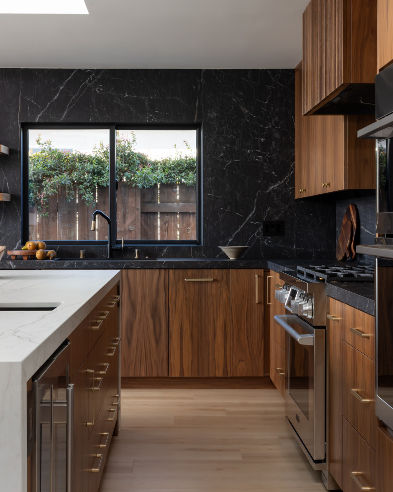 Ispirazione per un cucina con isola centrale minimalista con ante lisce, ante in legno bruno, top in superficie solida, paraspruzzi nero e top nero