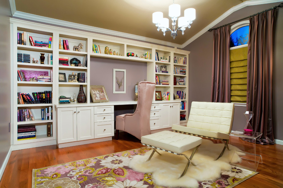This is an example of a mid-sized contemporary study room in St Louis with purple walls, dark hardwood floors, a built-in desk and brown floor.
