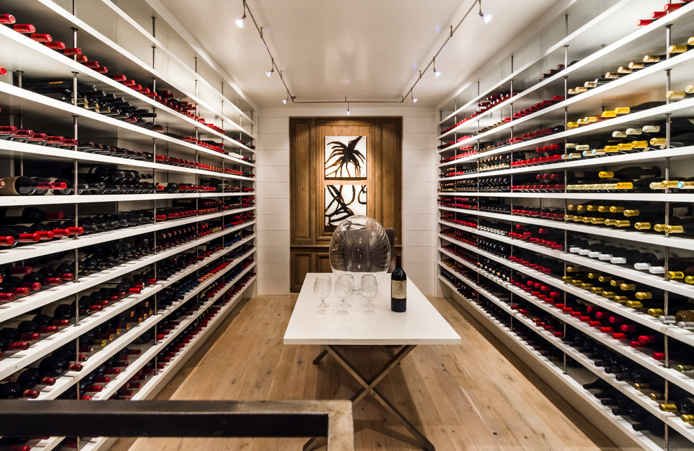 Photo of a large contemporary wine cellar in Atlanta with light hardwood floors and storage racks.