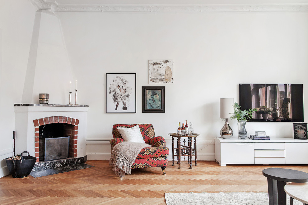 Design ideas for a mid-sized scandinavian formal open concept living room in Stockholm with white walls, light hardwood floors, a corner fireplace, a brick fireplace surround and a wall-mounted tv.