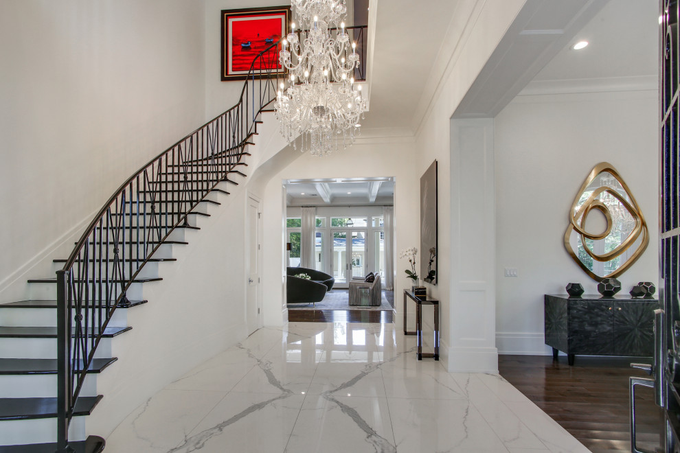 Photo of a large transitional foyer in New Orleans with white walls, marble floors, a double front door, a black front door, white floor and vaulted.