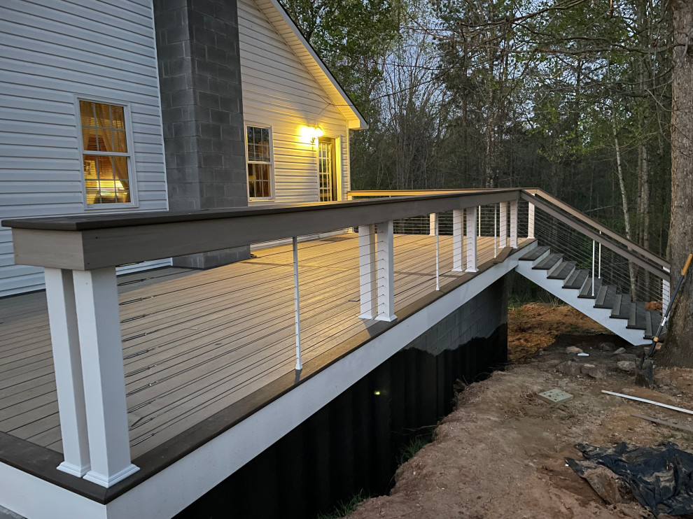 Photo of an expansive modern side yard and ground level deck in Richmond with cable railing.