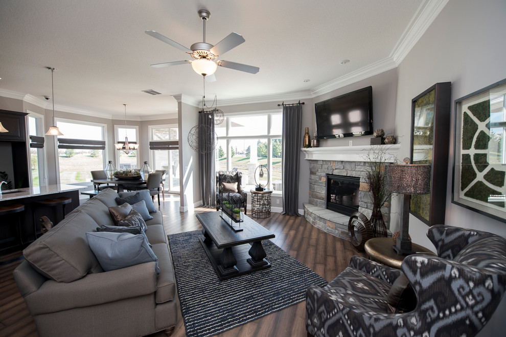 Photo of a mid-sized transitional open concept living room in Other with grey walls, a corner fireplace, a stone fireplace surround and a wall-mounted tv.