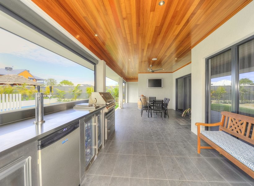 Large contemporary backyard patio in Perth with an outdoor kitchen, tile and a roof extension.
