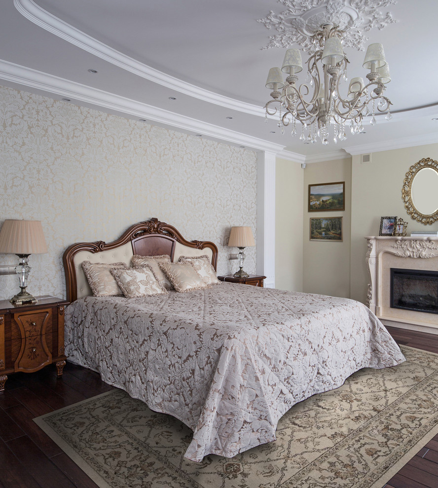 This is an example of a traditional master bedroom in Other with beige walls, dark hardwood floors, a standard fireplace and a stone fireplace surround.