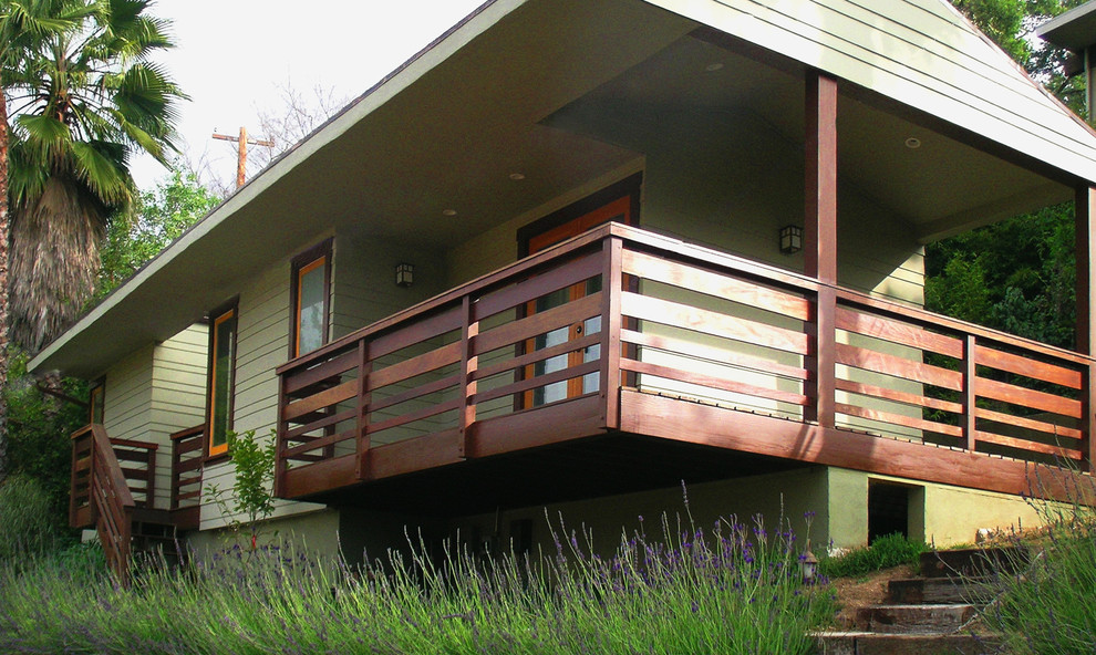 Photo of a large eclectic one-storey green exterior in Los Angeles with wood siding.