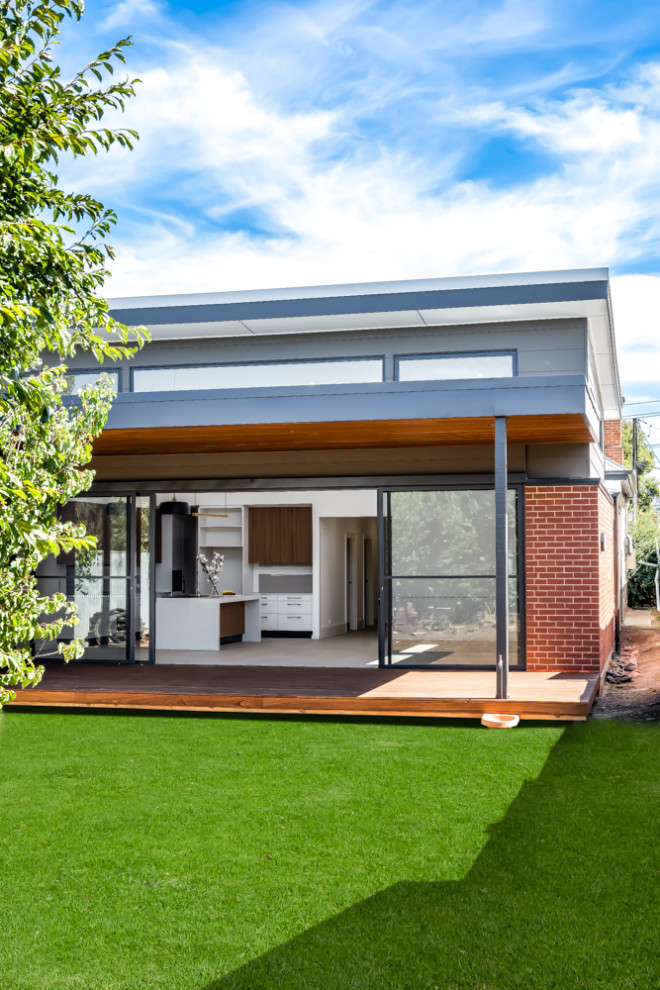 Design ideas for a mid-sized contemporary one-storey brick red house exterior in Adelaide with a flat roof, a metal roof, a white roof and clapboard siding.