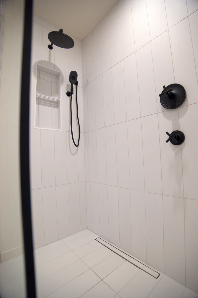 Inredning av ett modernt mellanstort vit vitt en-suite badrum, med släta luckor, blå skåp, en kantlös dusch, en toalettstol med separat cisternkåpa, vit kakel, porslinskakel, vita väggar, klinkergolv i porslin, ett integrerad handfat, bänkskiva i kvartsit, vitt golv och med dusch som är öppen