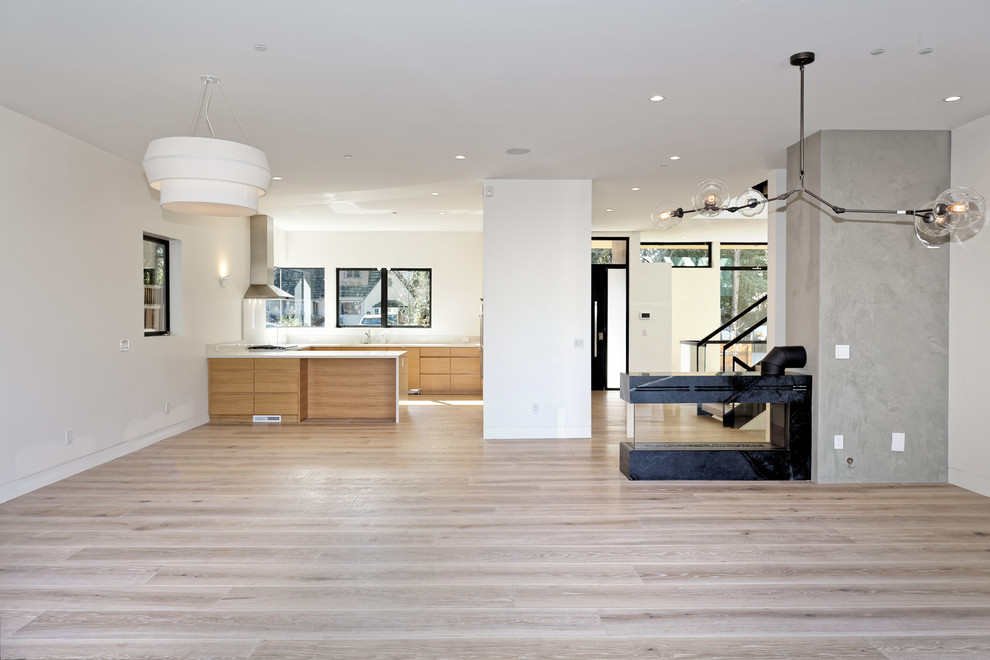 Photo of a mid-sized contemporary u-shaped separate kitchen in San Francisco with flat-panel cabinets, light wood cabinets, quartz benchtops, panelled appliances, medium hardwood floors, a peninsula, brown floor and white benchtop.