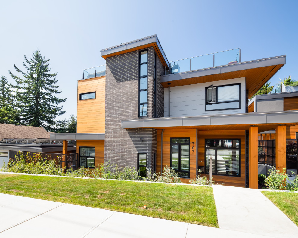 Large contemporary house exterior in Vancouver with a flat roof and a metal roof.