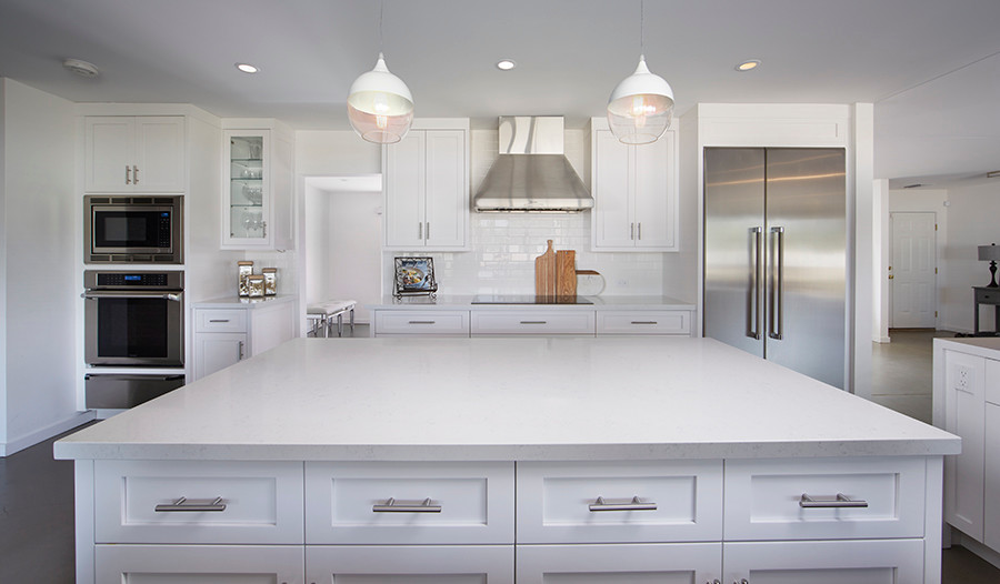 Design ideas for a contemporary kitchen in Phoenix with a farmhouse sink, shaker cabinets, quartz benchtops, white splashback, subway tile splashback, stainless steel appliances, concrete floors and with island.