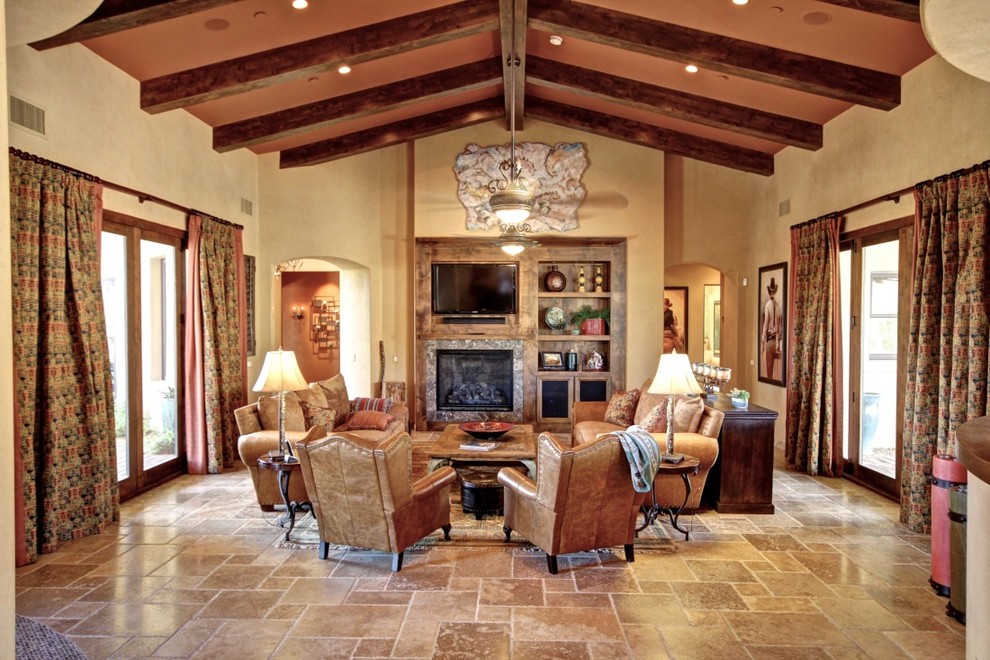Design ideas for a mid-sized traditional open concept family room in Phoenix with beige walls, limestone floors, a standard fireplace, a tile fireplace surround, a wall-mounted tv and brown floor.