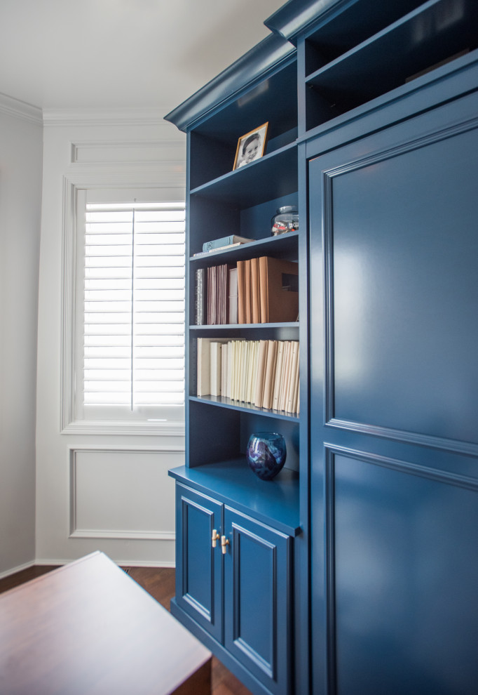 Design ideas for a mid-sized transitional gender-neutral storage and wardrobe in Denver with recessed-panel cabinets, blue cabinets, laminate floors and brown floor.