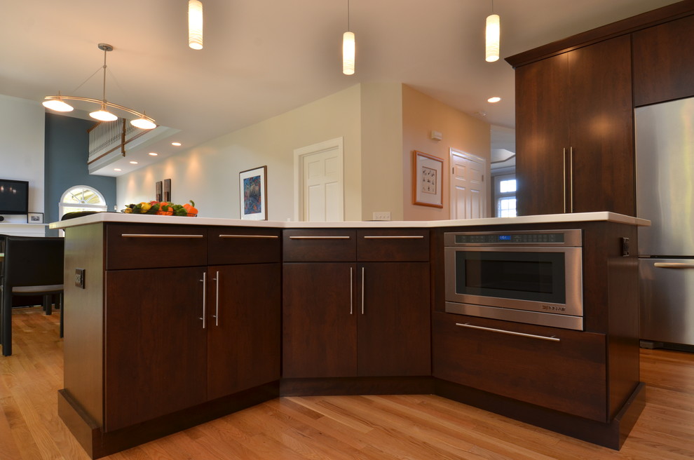 Mid-sized transitional l-shaped light wood floor eat-in kitchen photo in Chicago with an undermount sink, flat-panel cabinets, dark wood cabinets, quartzite countertops, multicolored backsplash, matchstick tile backsplash, stainless steel appliances and an island
