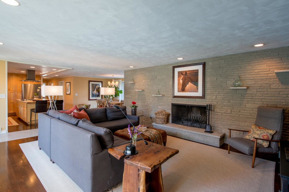 This is an example of a midcentury open concept living room in Columbus with a standard fireplace.