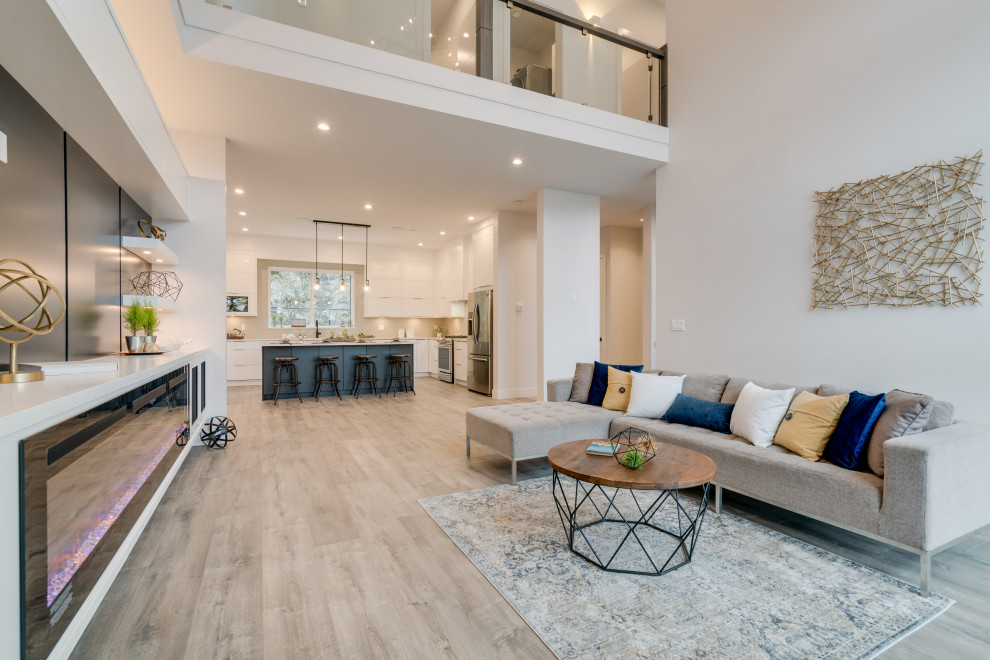 This is an example of a mid-sized contemporary open concept family room in Vancouver with white walls, laminate floors, a hanging fireplace, a wood fireplace surround, a built-in media wall and grey floor.
