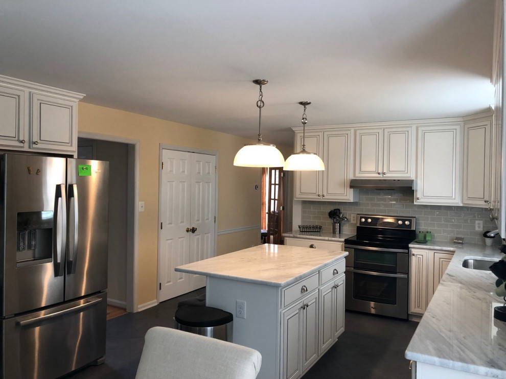 This is an example of a mid-sized traditional l-shaped eat-in kitchen in Oklahoma City with white cabinets, marble benchtops, subway tile splashback, stainless steel appliances and with island.