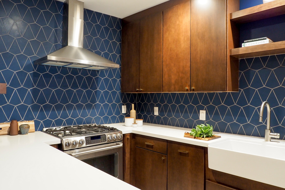 Photo of a small contemporary u-shaped separate kitchen in San Francisco with a farmhouse sink, flat-panel cabinets, dark wood cabinets, blue splashback, ceramic splashback, stainless steel appliances, ceramic floors, a peninsula, beige floor and white benchtop.