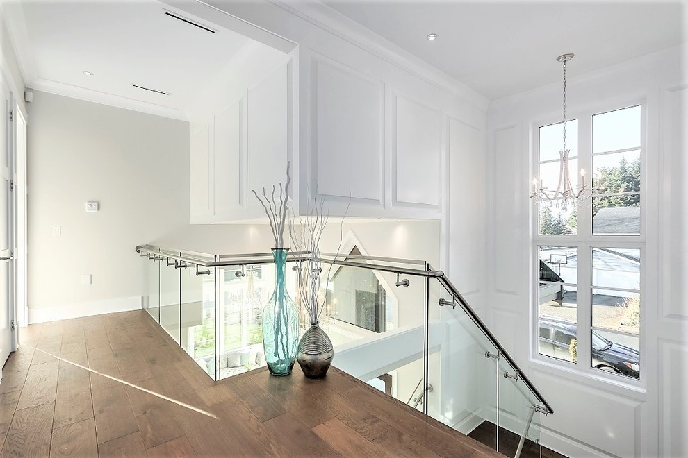 Mid-sized contemporary glass u-shaped staircase in Vancouver with glass risers and metal railing.