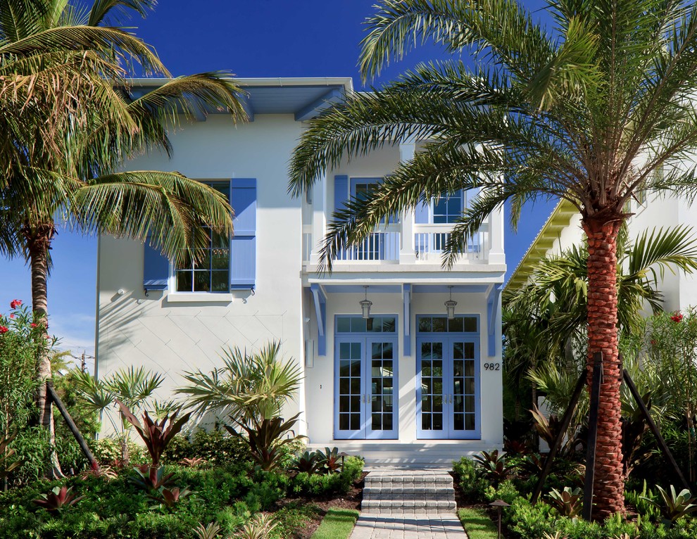 Design ideas for a tropical two-storey white exterior in Miami.