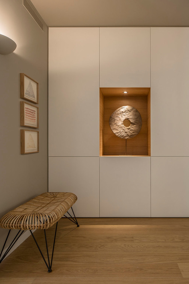 Imagen de recibidores y pasillos de tamaño medio con paredes blancas, suelo de madera en tonos medios y suelo marrón
