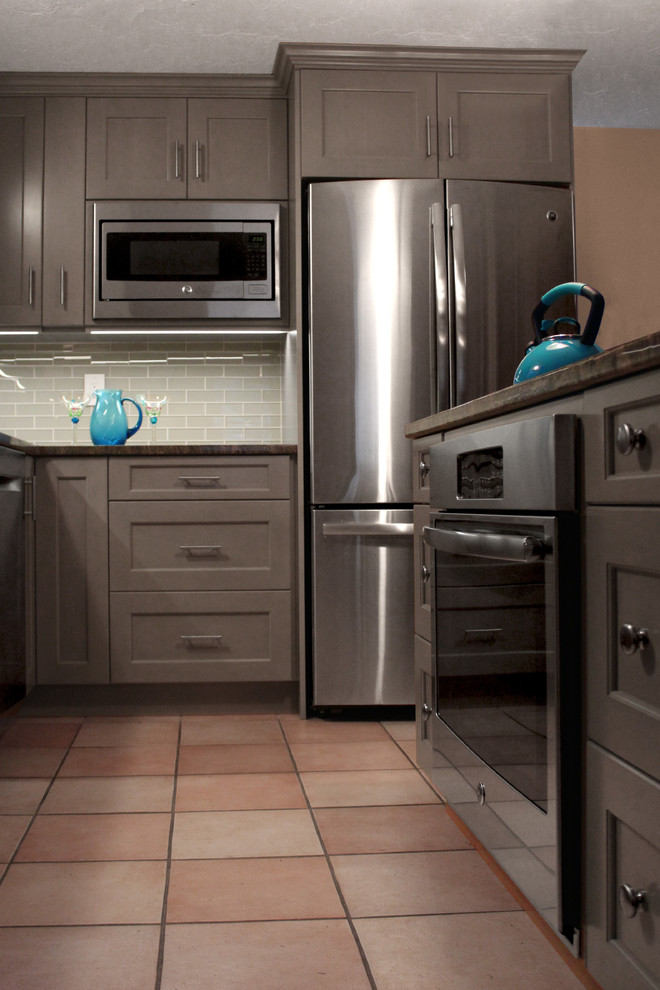 Eat-in kitchen - mid-sized transitional l-shaped ceramic tile eat-in kitchen idea in Boston with an undermount sink, shaker cabinets, gray cabinets, granite countertops, gray backsplash, glass tile backsplash, stainless steel appliances and an island
