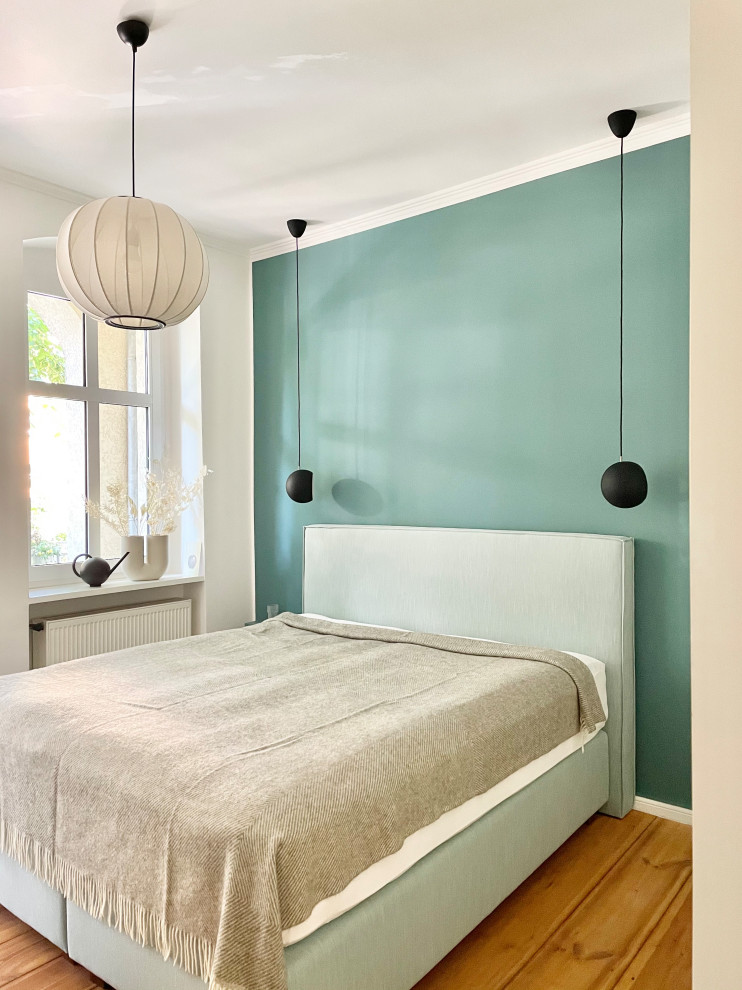 Idee per una piccola camera matrimoniale design con pareti blu, parquet chiaro e pavimento marrone