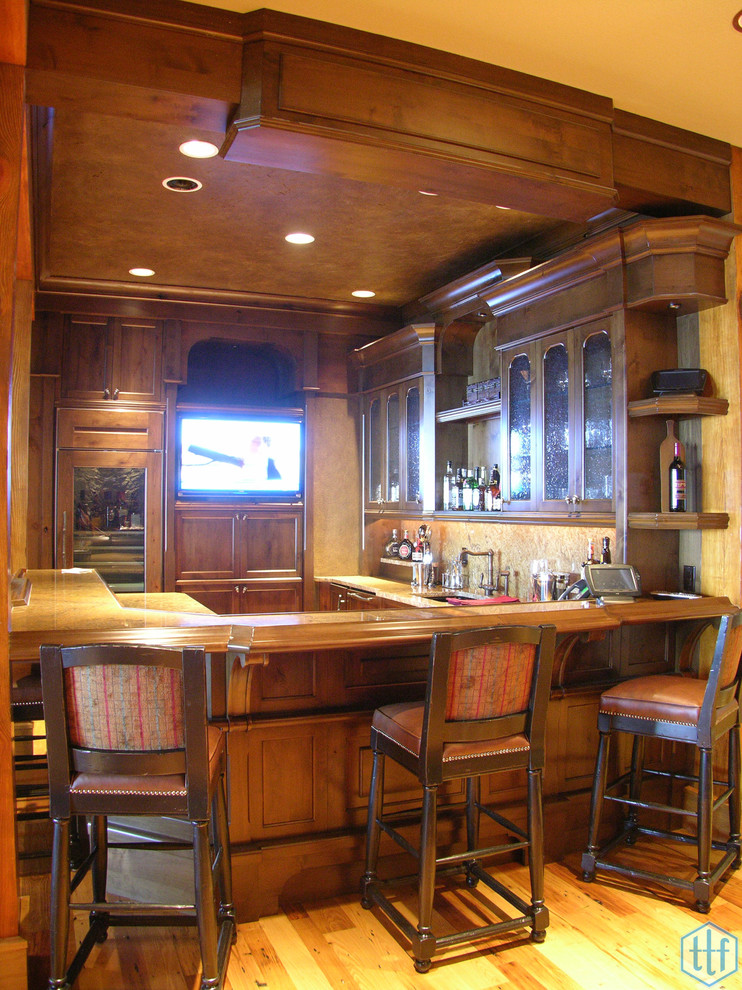 Seated home bar - large rustic u-shaped medium tone wood floor seated home bar idea in Miami with recessed-panel cabinets, medium tone wood cabinets, wood countertops and brown backsplash