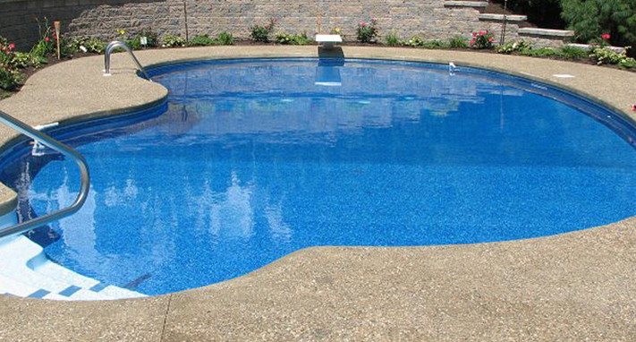 Example of a large backyard stone and custom-shaped pool design in Boston