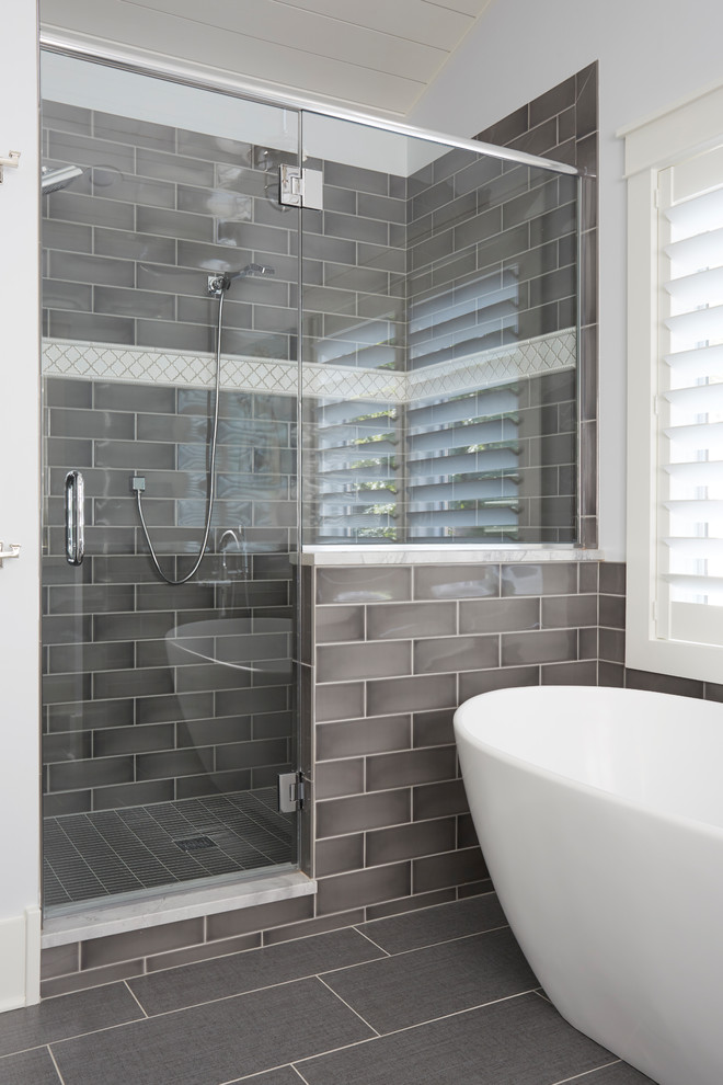 Design ideas for a large contemporary master bathroom in Milwaukee with a freestanding tub, a double shower, gray tile, ceramic tile, white walls, porcelain floors, grey floor and a hinged shower door.