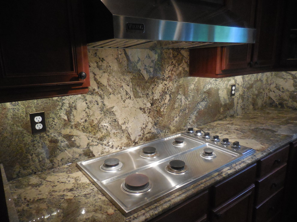 Kitchen - mid-sized transitional medium tone wood floor kitchen idea in Baltimore with an undermount sink, medium tone wood cabinets, granite countertops, multicolored backsplash, stone slab backsplash and stainless steel appliances