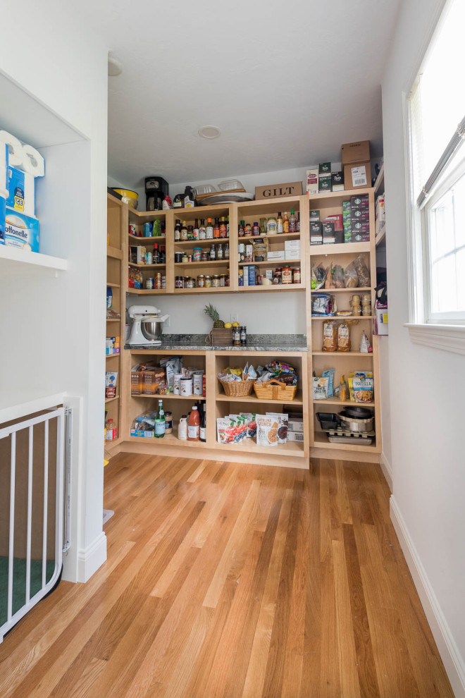Large transitional single-wall light wood floor and brown floor eat-in kitchen photo in Boston with a farmhouse sink, shaker cabinets, white cabinets, granite countertops, gray backsplash, ceramic backsplash, stainless steel appliances, an island and gray countertops