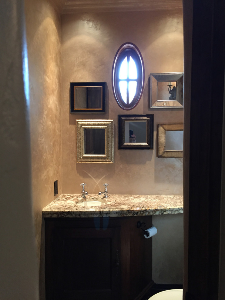 Photo of a small mediterranean powder room in Phoenix with beige walls, medium hardwood floors, an undermount sink, granite benchtops and a built-in vanity.