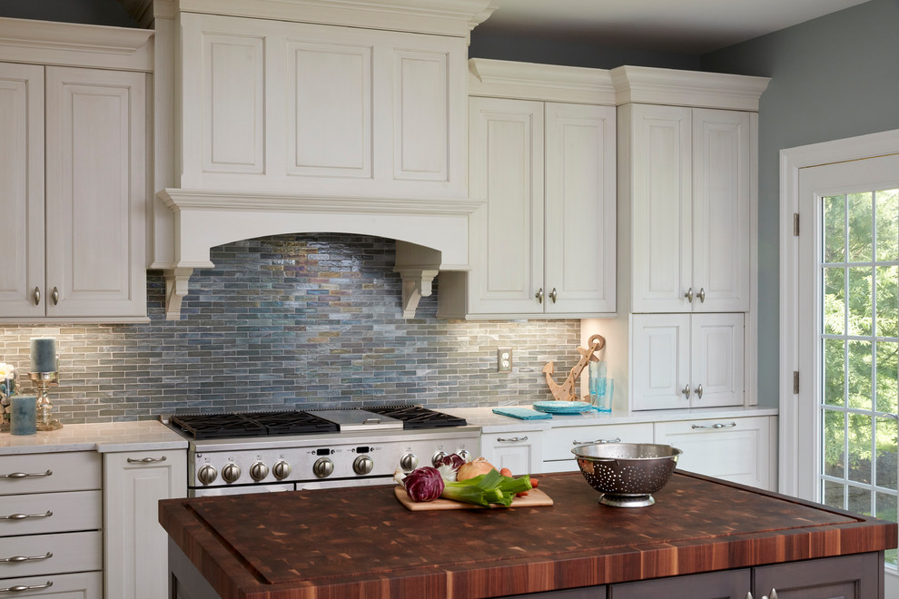 Inspiration for an expansive traditional u-shaped open plan kitchen in Baltimore with a farmhouse sink, raised-panel cabinets, white cabinets, quartz benchtops, blue splashback, mosaic tile splashback, stainless steel appliances, porcelain floors, multiple islands, grey floor and white benchtop.