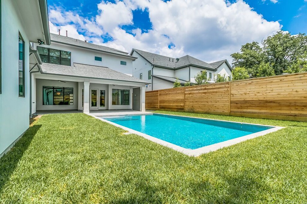 Transitional backyard concrete paver and rectangular lap pool photo in Houston