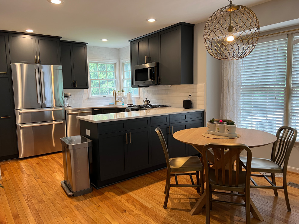 Open concept kitchen - small transitional u-shaped medium tone wood floor and brown floor open concept kitchen idea in Baltimore with an undermount sink, shaker cabinets, blue cabinets, quartz countertops, white backsplash, porcelain backsplash, stainless steel appliances, a peninsula and white countertops